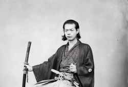 An black and white photograph of samurai sitting calmly on a chair.